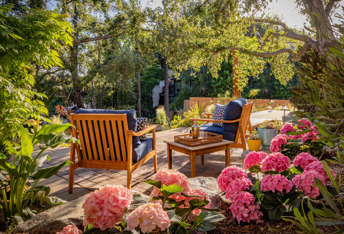 Altadena backyard patio with lounge chairs, stone steps, planting, and pond